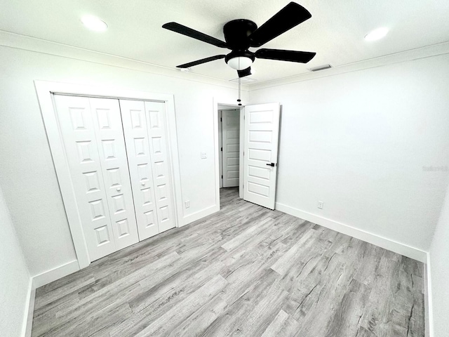 unfurnished bedroom with light wood-style floors, visible vents, crown molding, and baseboards