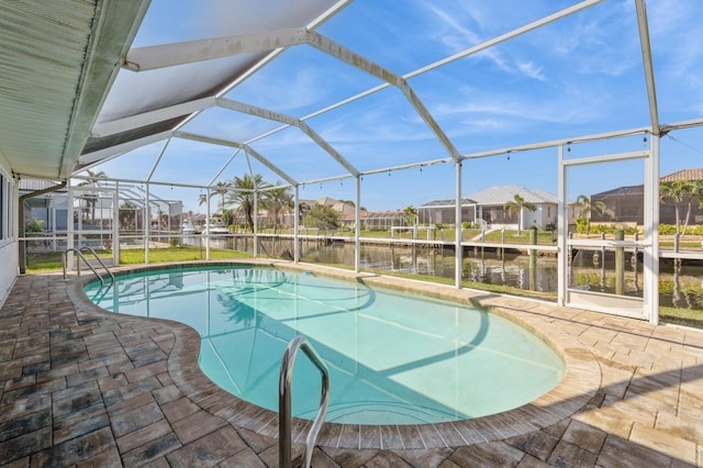 view of pool with a water view, glass enclosure, and a patio area