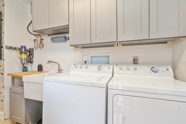 clothes washing area featuring cabinets and washing machine and dryer