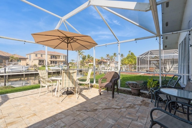 view of patio / terrace with a water view, a dock, and glass enclosure