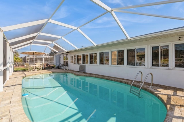 view of swimming pool with a patio area and glass enclosure