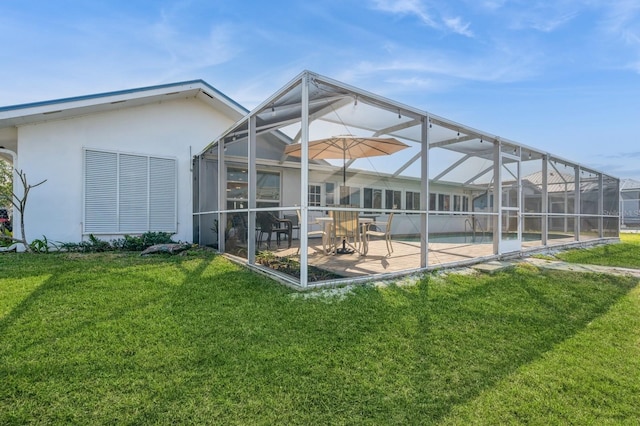 rear view of property with a patio, a lanai, and a yard