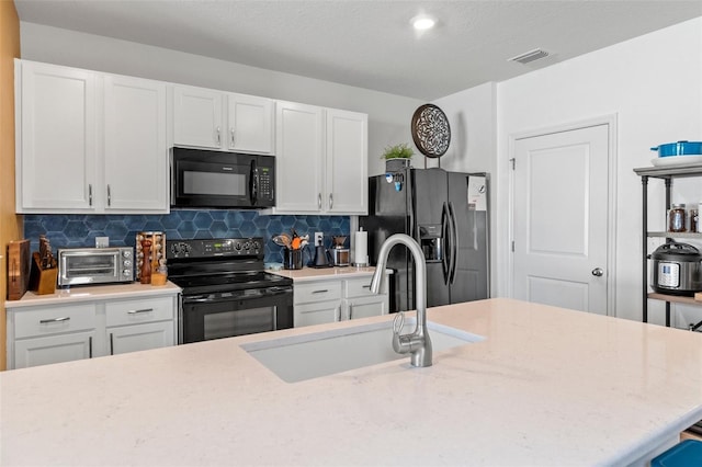 kitchen featuring white cabinets, sink, tasteful backsplash, and black appliances