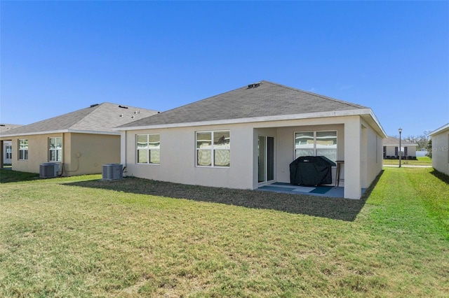 back of property featuring central air condition unit, a patio area, and a lawn