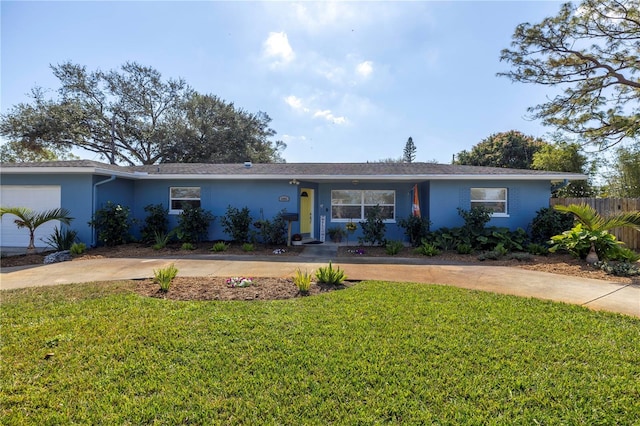 ranch-style house with concrete driveway, a front yard, and stucco siding