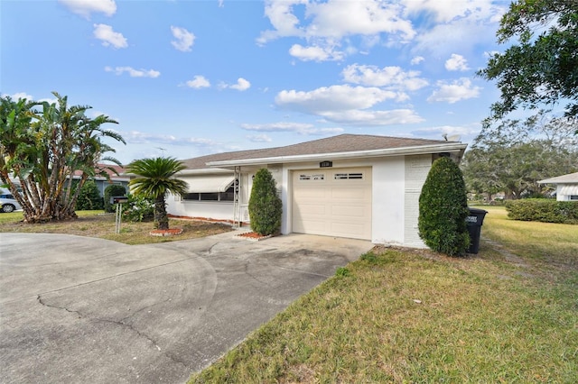 single story home with a garage and a front lawn