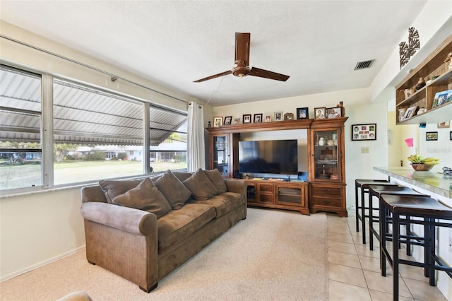 tiled living room featuring a textured ceiling and ceiling fan