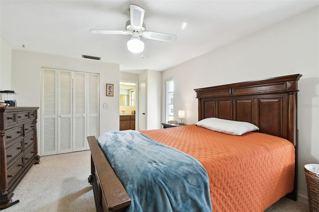 carpeted bedroom featuring connected bathroom, a closet, and ceiling fan