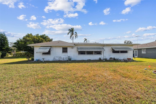 rear view of property featuring a lawn