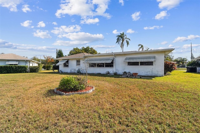 back of property with a lawn