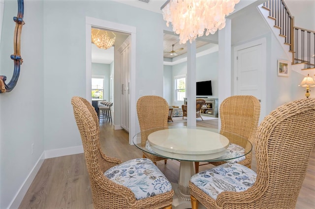 dining space with light hardwood / wood-style flooring and a chandelier