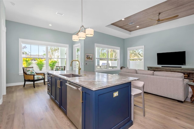 kitchen with pendant lighting, sink, blue cabinetry, an island with sink, and stainless steel dishwasher