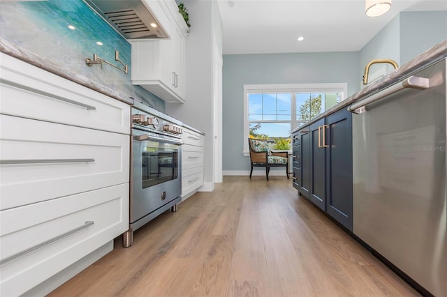 kitchen with white cabinets, blue cabinetry, oven, and light hardwood / wood-style floors