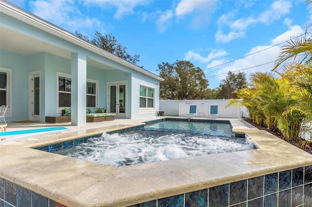 view of swimming pool with pool water feature and french doors