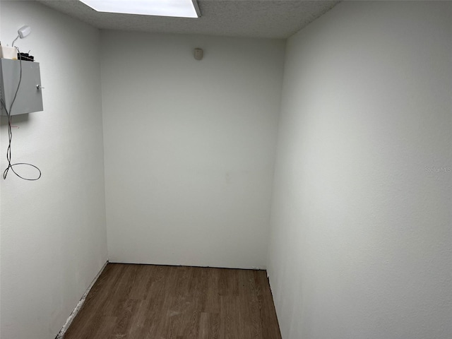 unfurnished room featuring dark wood-type flooring and a textured ceiling