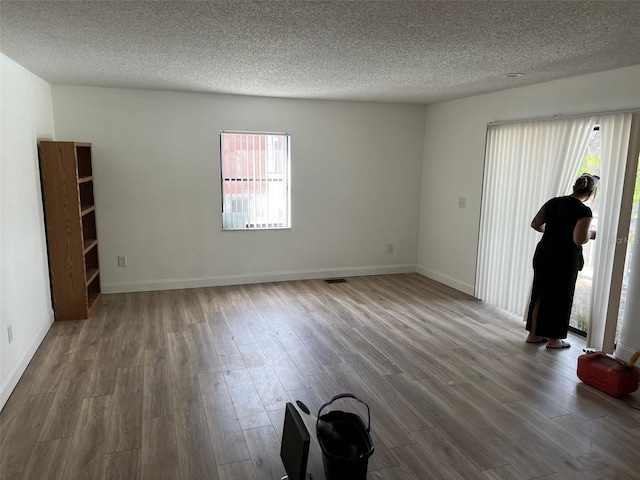 unfurnished room featuring hardwood / wood-style floors and a textured ceiling