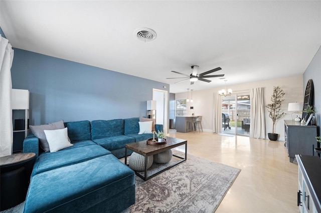 living room with ceiling fan with notable chandelier