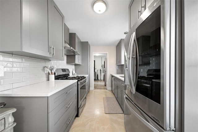 kitchen with gray cabinetry, stainless steel appliances, and backsplash