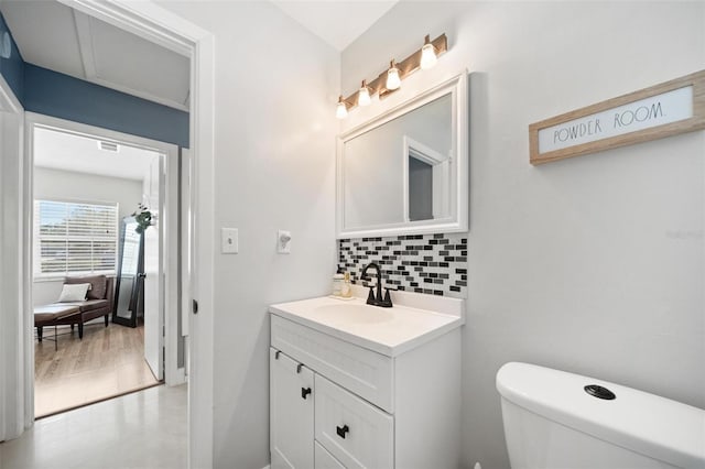 bathroom with vanity, toilet, and decorative backsplash