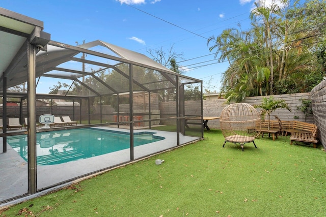 view of swimming pool with a fenced in pool, a lanai, a fenced backyard, and a lawn