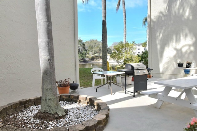 view of patio / terrace with outdoor dining area, a water view, and area for grilling