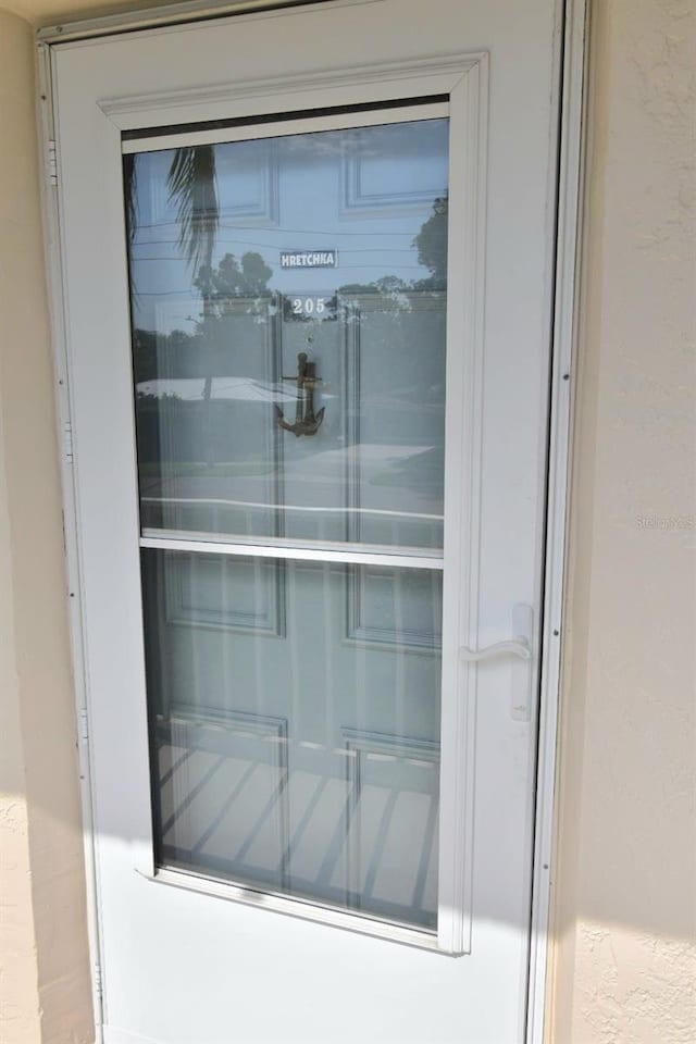 entrance to property with a garage and stucco siding