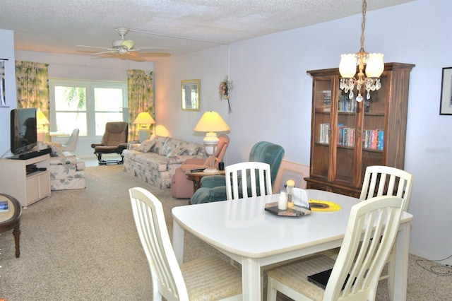 dining space with a textured ceiling, ceiling fan with notable chandelier, and carpet flooring