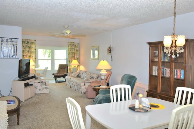 dining space featuring ceiling fan with notable chandelier, a textured ceiling, and light colored carpet