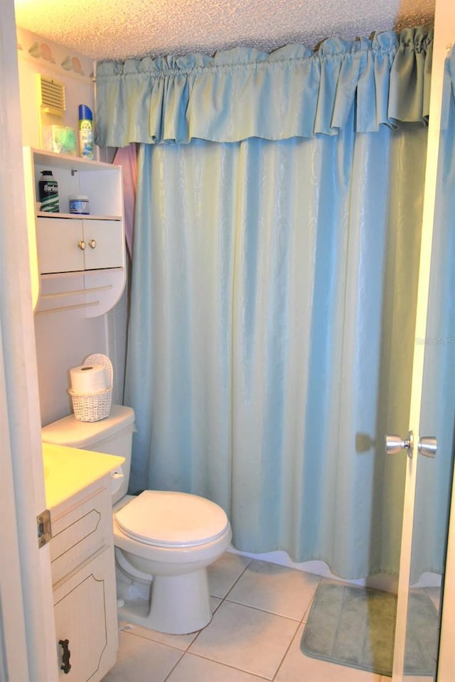 full bathroom featuring toilet, a textured ceiling, vanity, and tile patterned floors