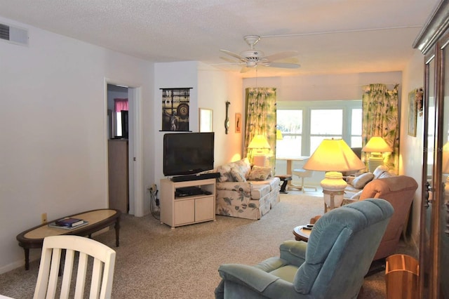 carpeted living area featuring visible vents, ceiling fan, and a textured ceiling