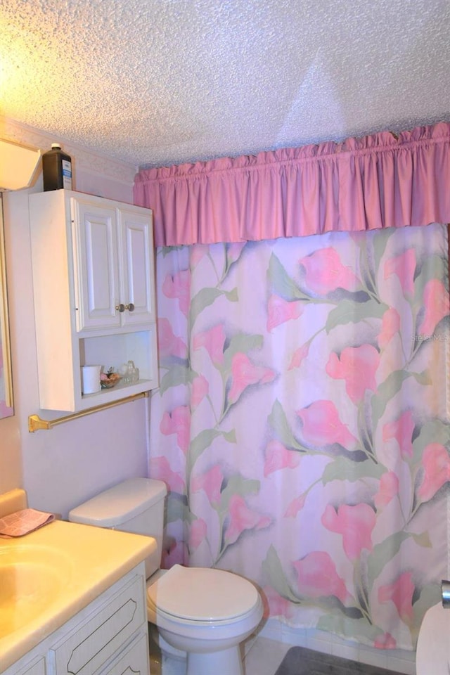 full bath featuring a textured ceiling, toilet, vanity, and a shower with curtain