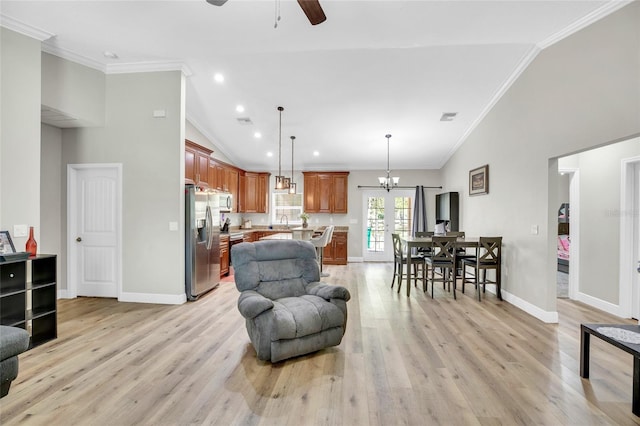 living room featuring ornamental molding, sink, ceiling fan with notable chandelier, and light wood-type flooring