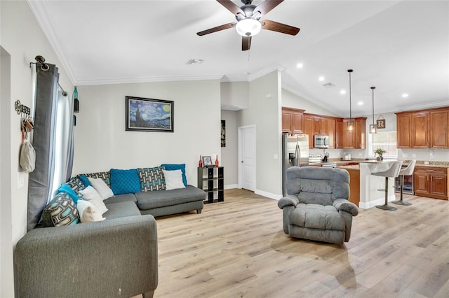 living room with crown molding, vaulted ceiling, and light hardwood / wood-style flooring