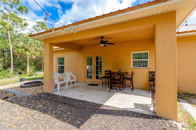 view of patio / terrace with french doors, ceiling fan, and a fire pit