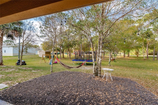 view of yard with a playground and a trampoline