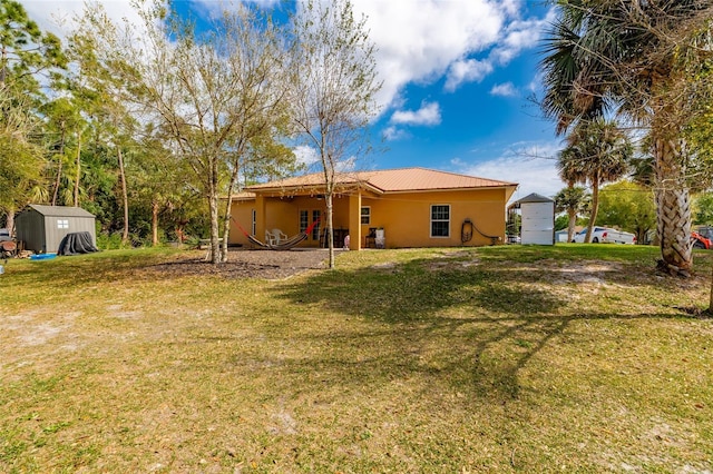 back of property featuring a storage shed and a lawn