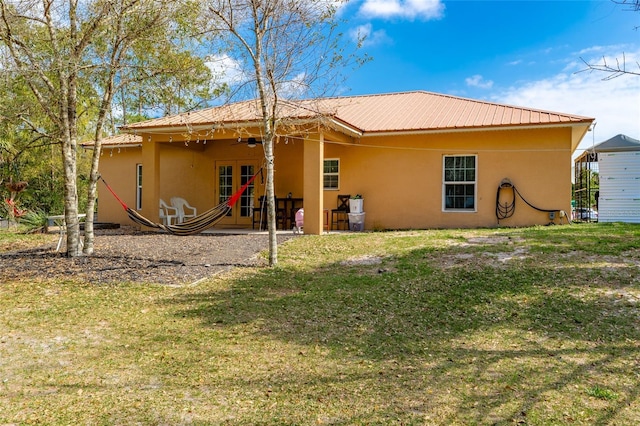 back of property with a yard and ceiling fan