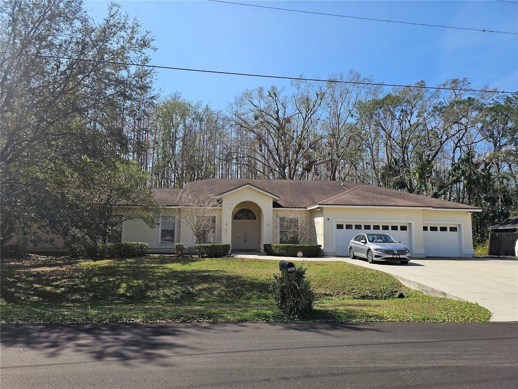 ranch-style house featuring a garage and a front yard