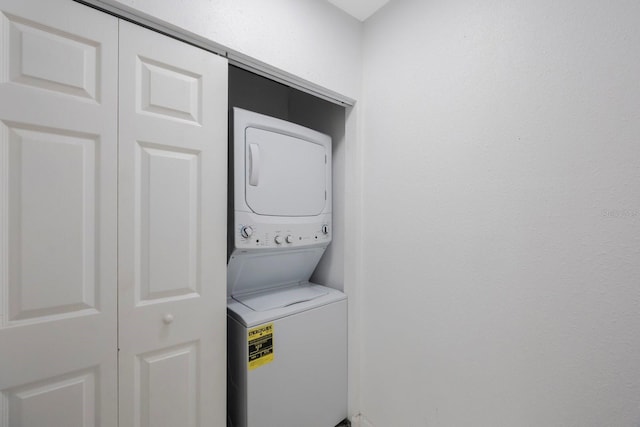 washroom with stacked washing maching and dryer