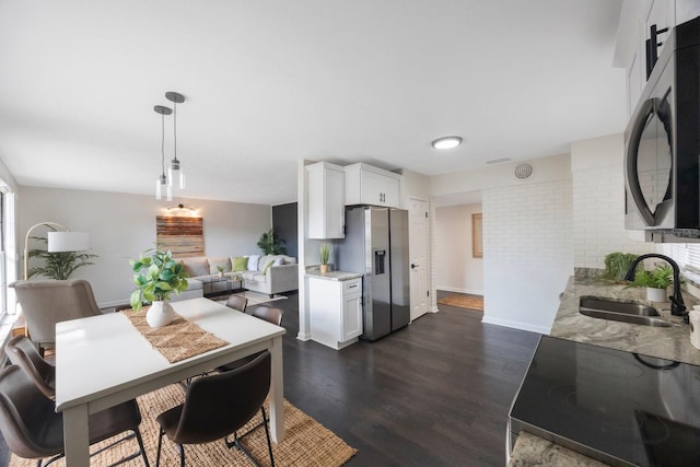 dining space featuring dark wood-type flooring and sink