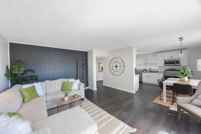 living room with dark hardwood / wood-style floors, sink, and a textured ceiling