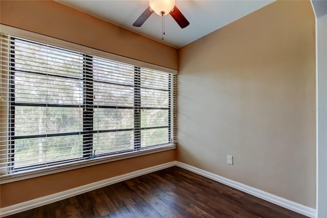 empty room with ceiling fan and dark hardwood / wood-style flooring