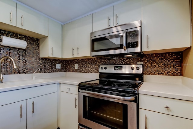 kitchen with stainless steel appliances, white cabinetry, sink, and decorative backsplash