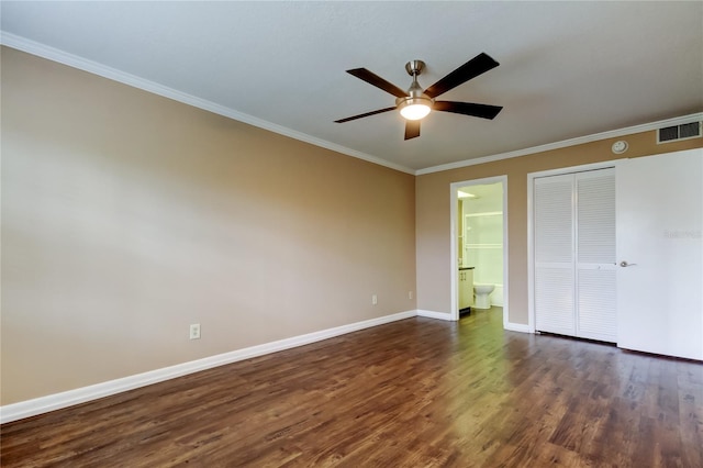 unfurnished bedroom with connected bathroom, dark hardwood / wood-style flooring, ornamental molding, ceiling fan, and a closet