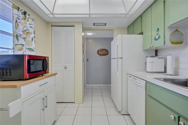 kitchen with white cabinetry, backsplash, green cabinets, light tile patterned floors, and white dishwasher