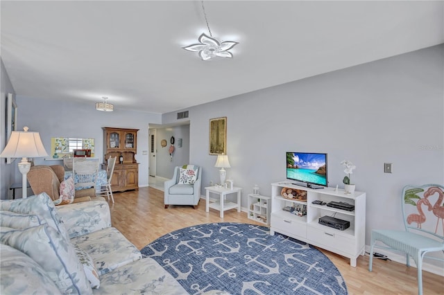 living room with light hardwood / wood-style flooring and a chandelier