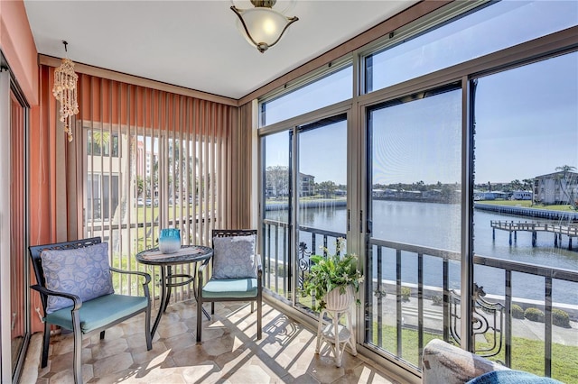 sunroom featuring a water view