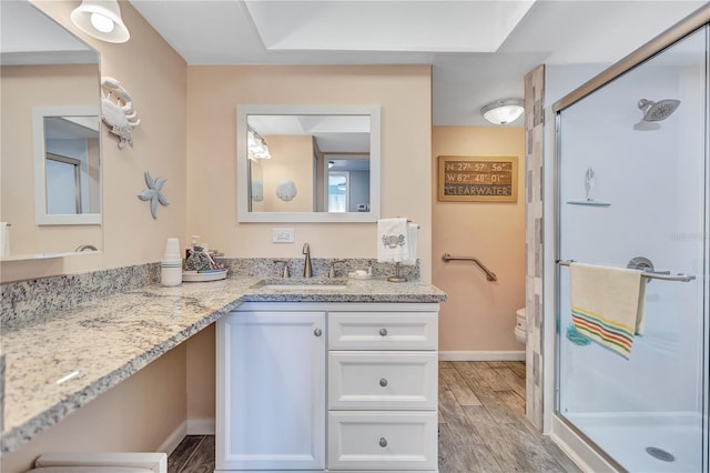 bathroom with an enclosed shower, vanity, and toilet