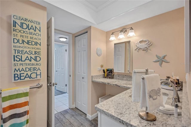 bathroom featuring crown molding, vanity, and hardwood / wood-style flooring