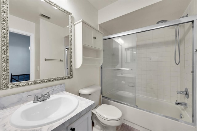 full bathroom featuring enclosed tub / shower combo, vanity, and toilet